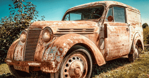 Old rusted out car sitting in a field