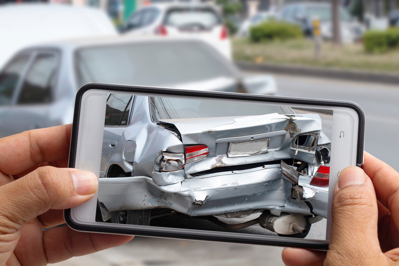 Phone showing a damaged car after a crash.